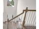 Bright and airy staircase with wood railing, carpet runner, and large window at landing at 2111 Fernbank Way, Dacula, GA 30019