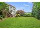 Spacious backyard with lush green grass, mature trees, and a wooden deck, perfect for outdoor activities at 249 Thorncliff Lndg, Acworth, GA 30101