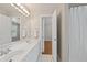 Well-lit bathroom featuring double sinks, modern fixtures, and white tiling with a door to the bedroom at 249 Thorncliff Lndg, Acworth, GA 30101