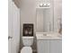 This bathroom has bright white cabinets, sink, toilet and a decorative mirror to add design and character at 249 Thorncliff Lndg, Acworth, GA 30101