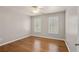 A cozy bedroom has hardwood floors and is brightened by windows with white trim and plantation shutters at 249 Thorncliff Lndg, Acworth, GA 30101