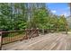 View of the backyard from the wooden deck and iron railings, with plenty of tree coverage at 249 Thorncliff Lndg, Acworth, GA 30101