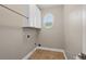 Empty Laundry Room with an oval window, white cabinets, and tile floor at 249 Thorncliff Lndg, Acworth, GA 30101