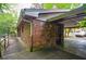 Exterior showcasing a brick house with a charming wooden porch and adjacent carport at 3082 Corbin Ave, Decatur, GA 30034