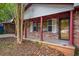A quaint front porch features brick columns and offers a shaded area to relax near the yard at 3082 Corbin Ave, Decatur, GA 30034