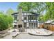 Landscaped backyard with outdoor fireplace, seating area, and elegant home exterior at 50 Dartmouth Ave, Avondale Estates, GA 30002
