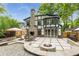 Inviting backyard with a stone patio, outdoor seating, a built-in fire pit, and lush landscaping at 50 Dartmouth Ave, Avondale Estates, GA 30002