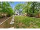 Lush backyard with stone walkway leading to a Tudor home and inviting patio at 50 Dartmouth Ave, Avondale Estates, GA 30002