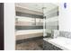 Walk-in shower with decorative wall and pebble-stone floor tiles adjacent to a mosaic-tiled tub at 50 Dartmouth Ave, Avondale Estates, GA 30002