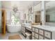Elegant bathroom with dual vanity, soaking tub, and stylish lighting fixtures at 50 Dartmouth Ave, Avondale Estates, GA 30002