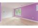 Bright bedroom with purple accent wall and hardwood floors at 50 Dartmouth Ave, Avondale Estates, GA 30002