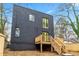 Modern two-story home featuring black siding, a wooden deck, and bright yellow doors at 2402 Lynn Iris Dr, Decatur, GA 30032