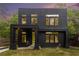 Modern two-story home features a black exterior, a bright yellow door, and many windows at 2402 Lynn Iris Dr, Decatur, GA 30032