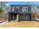 Modern two-story home with a striking black facade, complemented by a vibrant yellow front door at 2402 Lynn Iris Dr, Decatur, GA 30032