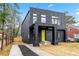 Stylish home featuring a black exterior, a bright yellow door, and a well-maintained front yard at 2402 Lynn Iris Dr, Decatur, GA 30032