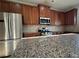 Kitchen area with wooden cabinets, granite counters, and stainless appliances at 3592 Hancock Vw, Decatur, GA 30034