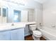 A bathroom featuring a toilet, sink with vanity, and a tiled shower-tub combo at 414 Ridge Creek Dr, Clarkston, GA 30021