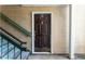 Close-up of the brown front door accented with gold hardware and green stairway at 414 Ridge Creek Dr, Clarkston, GA 30021
