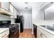 Functional kitchen with vintage black appliances, neutral countertops, and updated white cabinetry at 414 Ridge Creek Dr, Clarkston, GA 30021