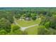 A beautiful brick two-story home with a three-car detached garage surrounded by lush green lawns and mature trees at 130 Plantation Dr, Stockbridge, GA 30281
