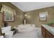 Relaxing bathroom featuring a jacuzzi tub, toilet, and wood cabinets at 130 Plantation Dr, Stockbridge, GA 30281