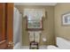 Cozy full bathroom with a window over the toilet and a bathtub with white shower curtain at 130 Plantation Dr, Stockbridge, GA 30281