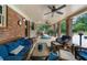 Inviting covered patio with ceiling fans, brick columns, and comfortable seating for outdoor living and entertaining at 130 Plantation Dr, Stockbridge, GA 30281