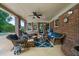 Inviting covered patio with comfortable seating, ceiling fan and brick accents at 130 Plantation Dr, Stockbridge, GA 30281