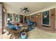 Cozy covered patio with comfortable seating area, ceiling fan and brick accents at 130 Plantation Dr, Stockbridge, GA 30281