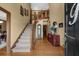 Foyer with hardwood floors, staircase, grandfather clock, and a view into the dining room at 130 Plantation Dr, Stockbridge, GA 30281