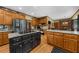 Open kitchen with granite countertops, oak cabinetry, a stainless steel refrigerator and black kitchen island at 130 Plantation Dr, Stockbridge, GA 30281