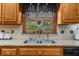 Close-up of the kitchen sink and granite countertops complemented by oak cabinets and stylish backsplash at 130 Plantation Dr, Stockbridge, GA 30281