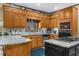 Well-lit kitchen featuring oak cabinets, granite countertops, stainless steel appliances, and a black kitchen island at 130 Plantation Dr, Stockbridge, GA 30281