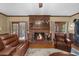 Living room boasts a brick fireplace, hardwood floors, and French doors leading to a sunroom at 130 Plantation Dr, Stockbridge, GA 30281