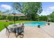 Backyard pool with table and umbrella offering a cool and relaxing spot for outdoor gatherings at 130 Plantation Dr, Stockbridge, GA 30281