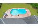 Aerial view of a backyard pool with diving board, surrounded by a brick patio and lush green lawn at 130 Plantation Dr, Stockbridge, GA 30281