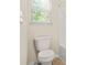 Bathroom showcasing a white toilet and a bright window view at 15 Manas Ct, Covington, GA 30016