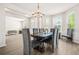 Elegant dining room with modern chandelier, bright windows, and open access to other rooms at 15 Manas Ct, Covington, GA 30016