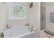 Bathroom featuring a soaking tub next to the window, and a glass door shower at 2034 Reavis Blf, Conyers, GA 30012