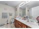 Bright bathroom featuring double sinks with wood cabinets, tile flooring, and a large mirror at 2034 Reavis Blf, Conyers, GA 30012