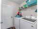 Functional laundry room with washer, dryer, shelving, and storage space at 2034 Reavis Blf, Conyers, GA 30012