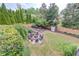 Private backyard with a cozy fire pit area surrounded by lush landscaping and mature trees at 2112 Ivey Chase Dr, Dacula, GA 30019