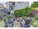 Landscaped backyard with stone firepit area with seating, lush plantings and mature trees at 2112 Ivey Chase Dr, Dacula, GA 30019