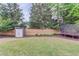 Fenced backyard with lush grass, storage shed, manicured shrubs and a trampoline at 2112 Ivey Chase Dr, Dacula, GA 30019