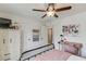 This is a bedroom with a ceiling fan, a cabinet, a wooden desk and photos on the wall at 2112 Ivey Chase Dr, Dacula, GA 30019
