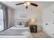 Bedroom features a ceiling fan, a cushioned headboard, a side table with drawers, and gray curtains at 2112 Ivey Chase Dr, Dacula, GA 30019