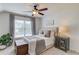 This bedroom features a ceiling fan, a cushioned headboard, a wooden trunk and a table with drawers at 2112 Ivey Chase Dr, Dacula, GA 30019