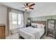 Comfortable bedroom with a ceiling fan, a modern accent wall, and natural light from the window at 2112 Ivey Chase Dr, Dacula, GA 30019