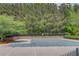 Community pool with a safety cover in a fenced in area surrounded by green trees at 2112 Ivey Chase Dr, Dacula, GA 30019