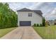 View of the side of this home showcasing the gray two car garage and concrete driveway at 2112 Ivey Chase Dr, Dacula, GA 30019